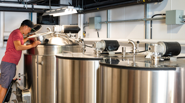 Une personne vérifiant le processus de distillation dans une brasserie