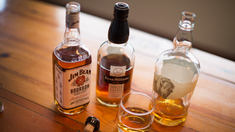 Bouteilles de bourbon sur une table en bois.