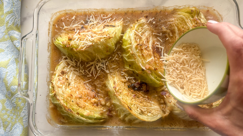 main ajoutant du parmesan au plat allant au four