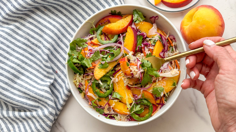 main avec une fourchette dans la salade