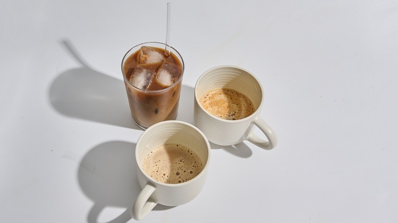 café glacé et deux tasses de café chaud sur une table