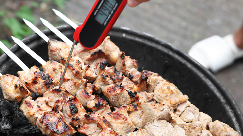 Les brochettes de poulet sont vérifiées avec un thermomètre à viande