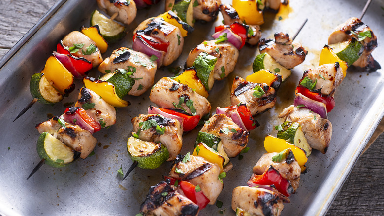 Les brochettes de poulet reposent sur un plateau