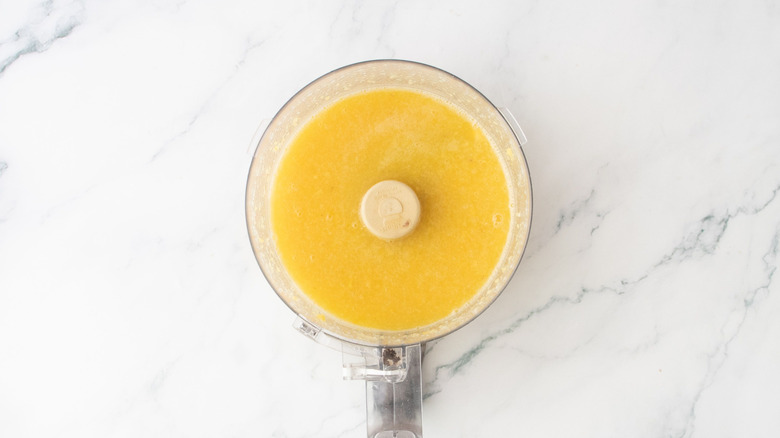 Jus de fruits tropicaux mélangés dans un robot culinaire