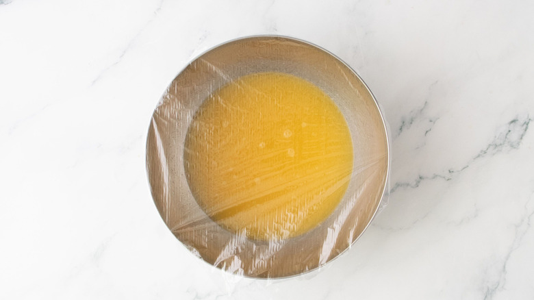 Jus de fruits tropicaux dans un bol recouvert de plastique