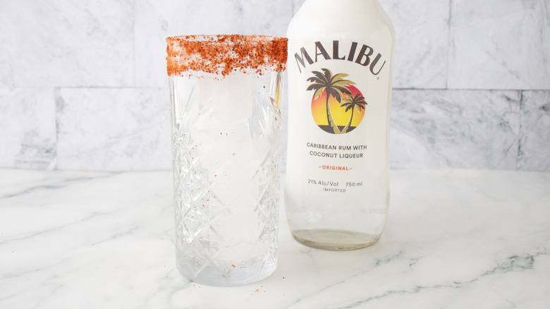 Verre à bord tajine devant une bouteille de rhum Malibu