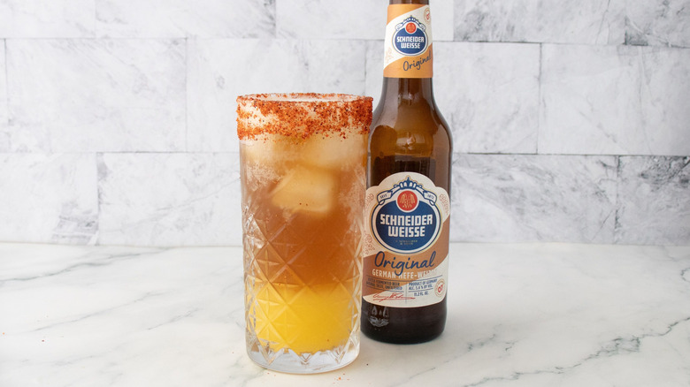 Rhum tropical panaché en verre devant une bouteille de bière
