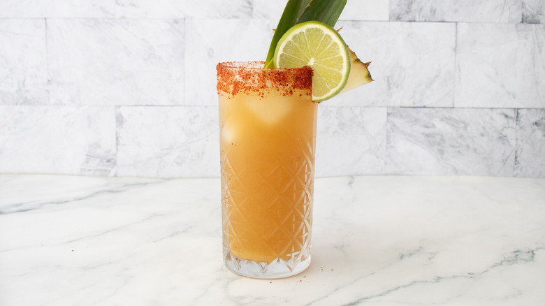 Panaché de rhum tropical en verre avec garnitures et bord Tajín