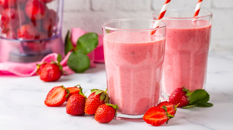 Lait aux fraises dans des verres avec des pailles