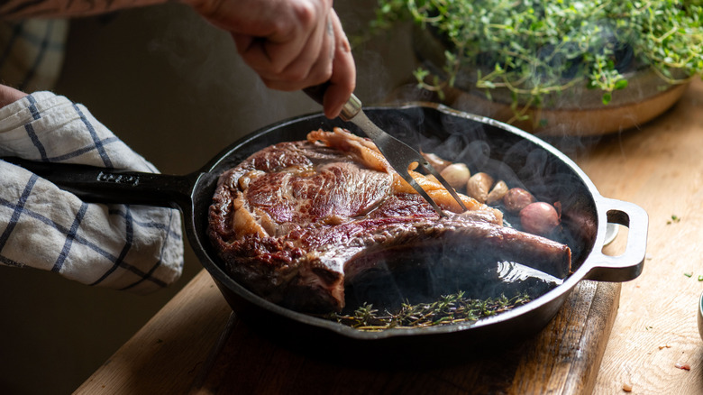 Un gros steak a été saisi dans une poêle en fonte.