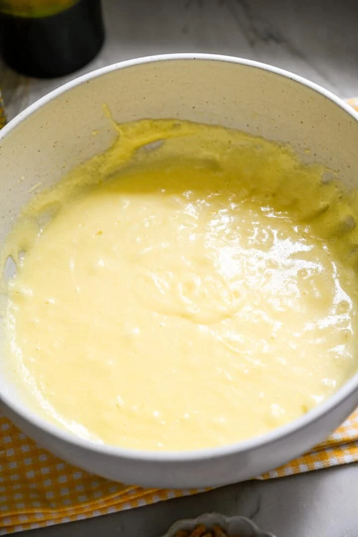 beurre, sucre et œufs mélangés dans un bol.