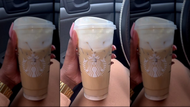Hnad tenant une infusion froide de crème sucrée à la vanille avec du moka au chocolat blanc