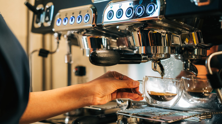 Machine à expresso dégoulinant d'espresso dans une petite tasse en verre