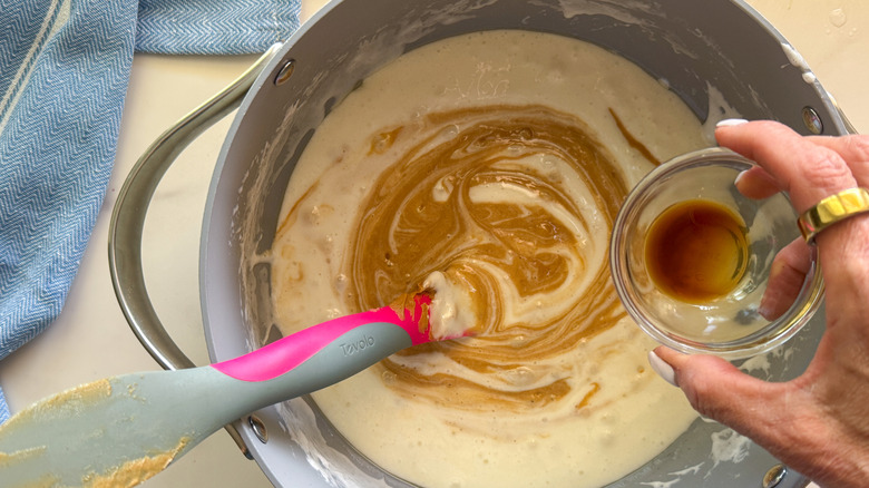 main ajoutant de la vanille au pot