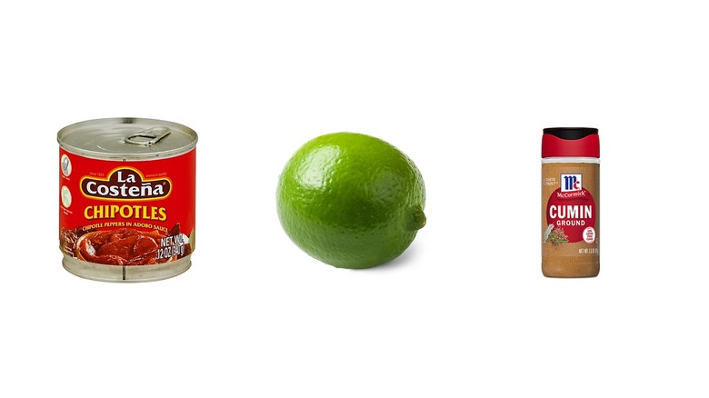 Une boîte de chipotles en sauce adobo, un citron vert et une bouteille de cumin moulu sur fond blanc isolé