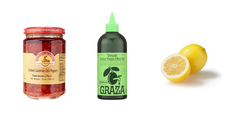 Une bouteille de pâte de piment calabrais, d'huile d'olive et de citron tranché sur fond blanc isolé