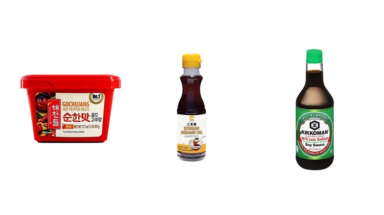 Un contenant de gochujang accompagné d'une bouteille d'huile de sésame et de sauce soja