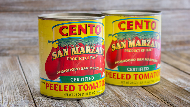 Deux boîtes de tomates San Marzano sur fond de bois.