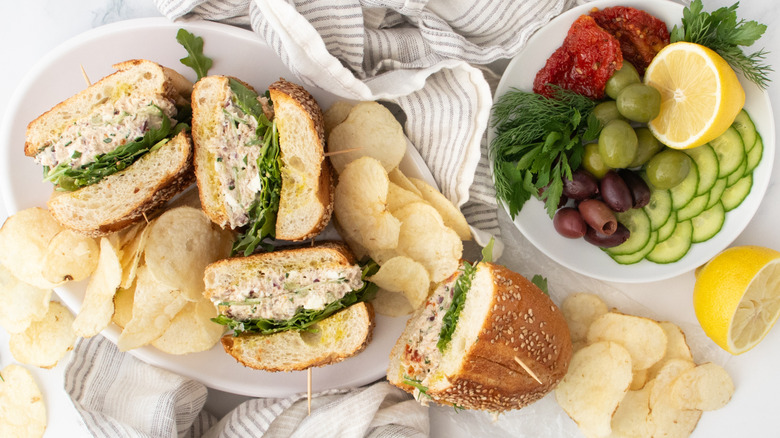 Photo aérienne de sandwichs à la salade de thon méditerranéens avec des ingrédients de salade à part.
