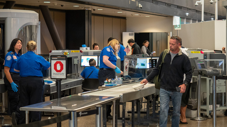 Ligne de sécurité aéroportuaire TSA avec passagers et agents