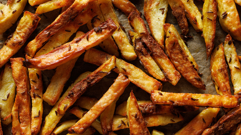 Frites aux graines de cumin sur papier sulfurisé