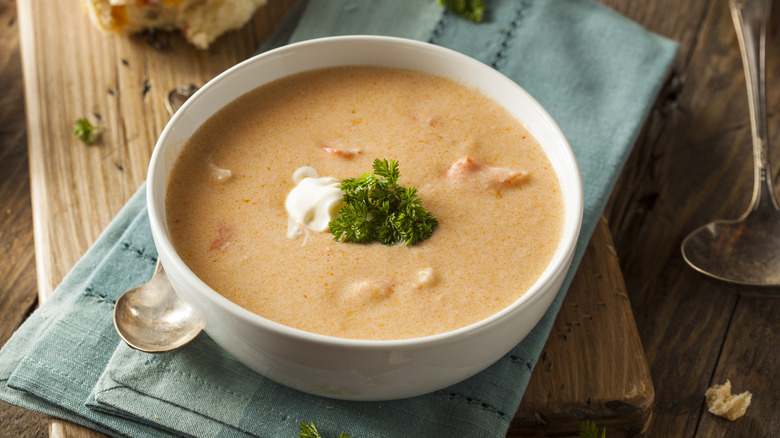 Un bol de bisque de homard riche et crémeuse sur une table avec une cuillère et une serviette