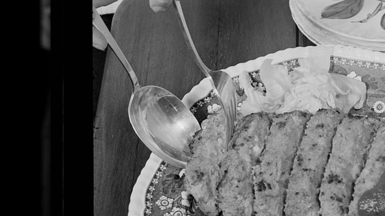 Photo en noir et blanc d'un pain de fèves au lard avec sauce sur une assiette fleurie.