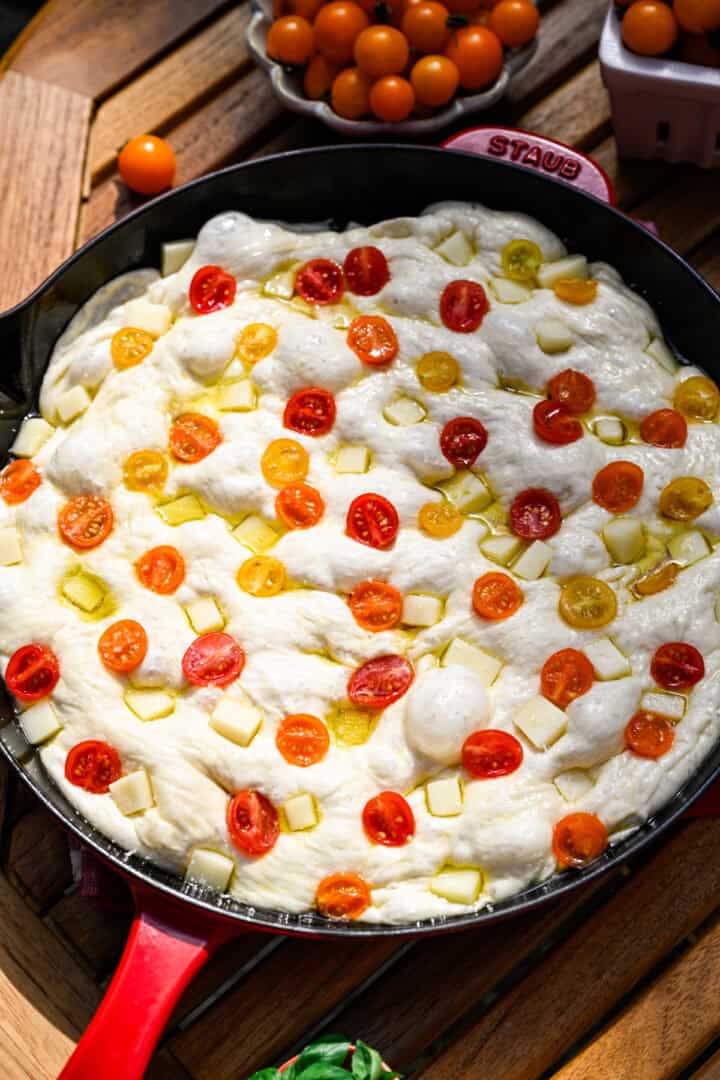 focaccia aux tomates dans la poêle avant la cuisson.