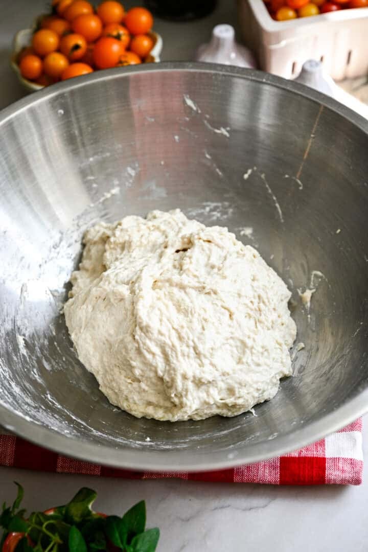 pâte à focaccia dans un bol en acier inoxydable.