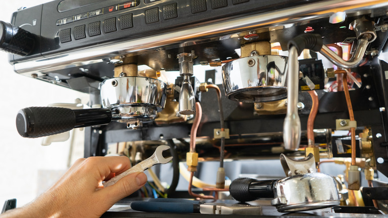 Les fils d'une machine à expresso sont réparés.