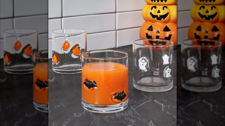 Trois verres à whisky différents avec des motifs effrayants de Target posés sur un comptoir de cuisine.