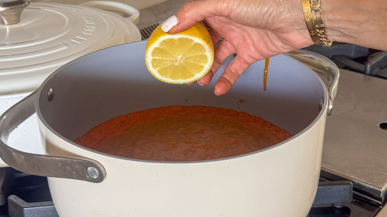 main ajoutant du citron au pot