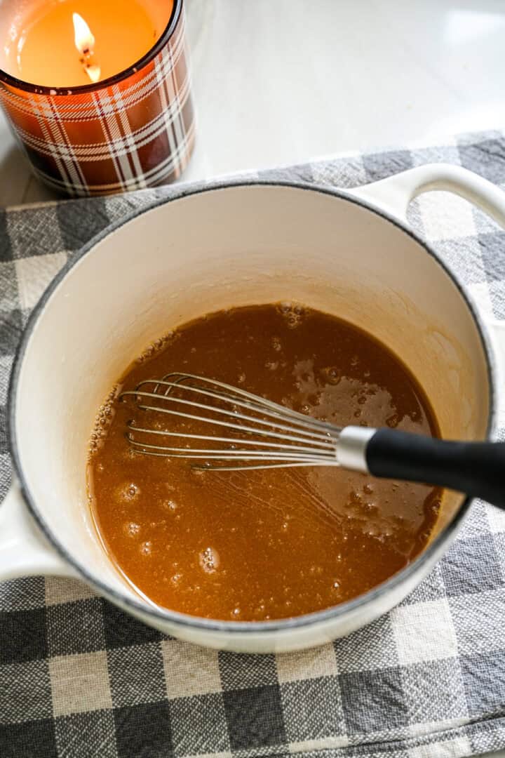 Le beurre et le sirop d'érable sont mélangés dans une petite casserole blanche.