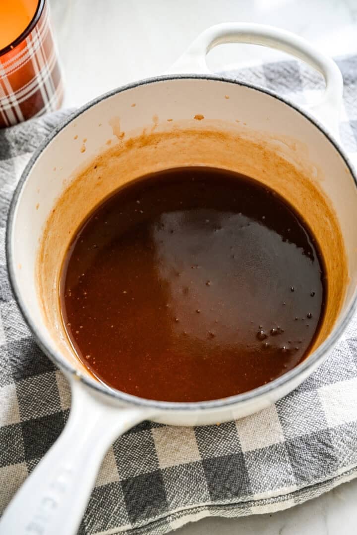 Sauce caramel aux dattes finie dans une petite casserole blanche.
