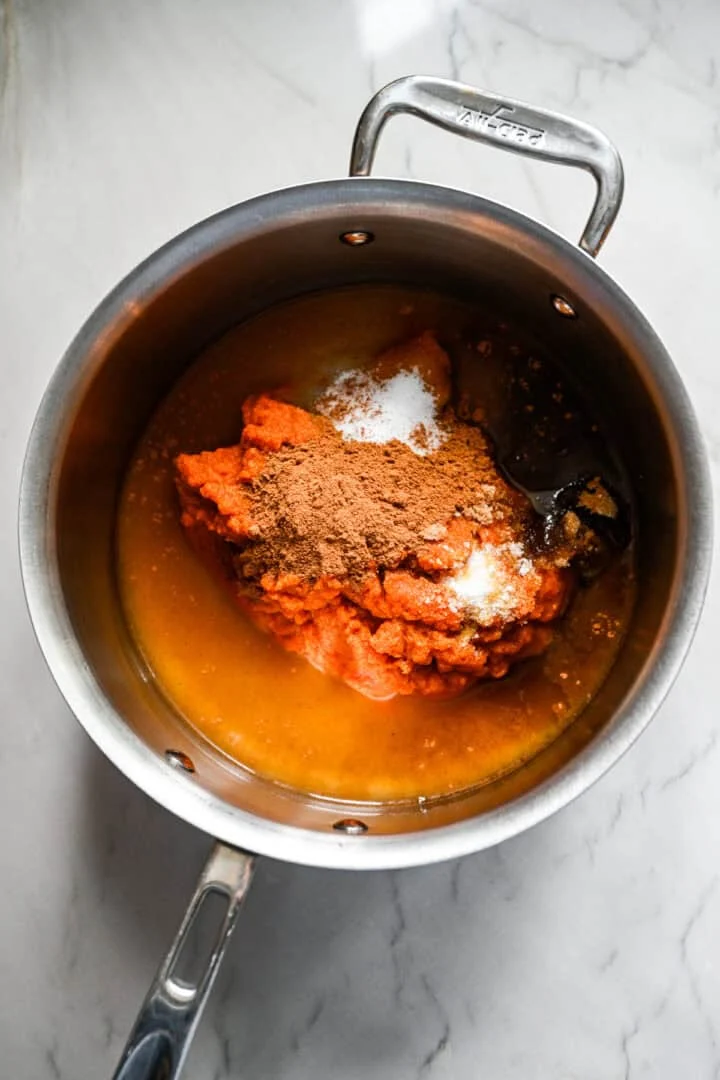 Tous les ingrédients du beurre de citrouille dans une casserole avant de mélanger.