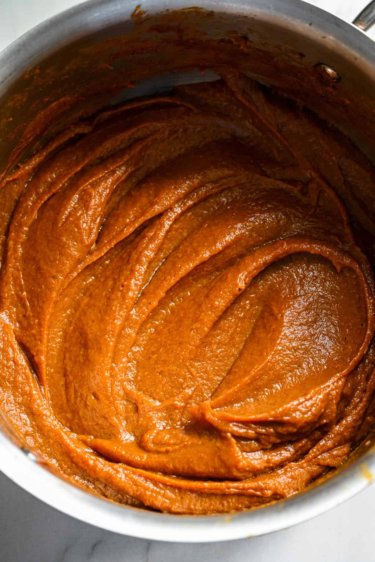 Vue rapprochée du beurre de citrouille fait maison dans une casserole après l'avoir cuit en une pâte épaisse.