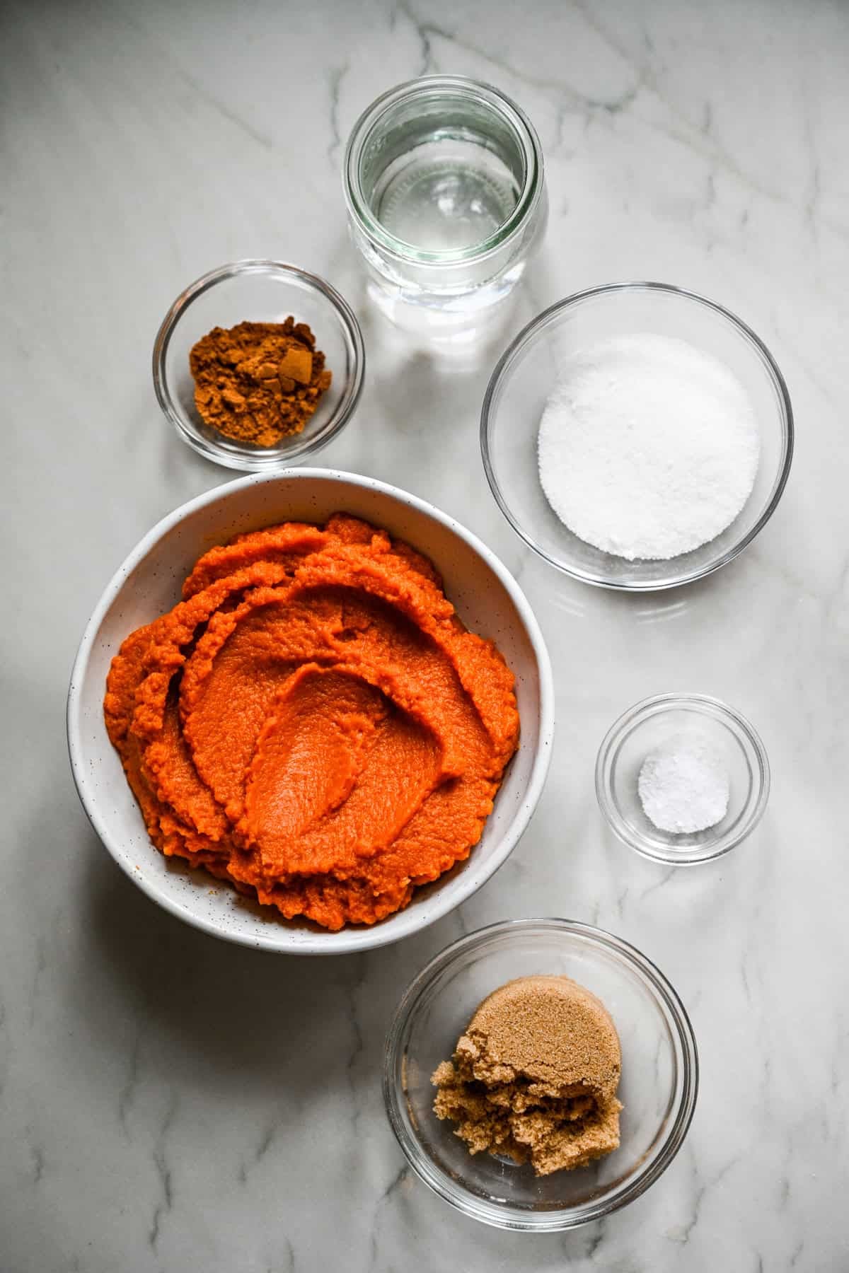 vue aérienne des ingrédients du beurre de citrouille fait maison dans de petits bols de préparation.