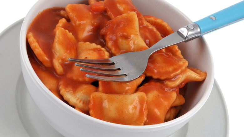 Un bol blanc de raviolis en conserve prêts à déguster.