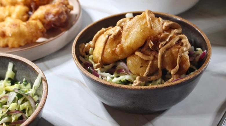 un bol de tacos au poisson Baja avec des protéines sur une salade de chou