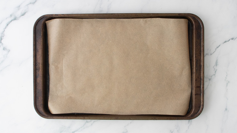 Une grande plaque à pâtisserie recouverte de papier sulfurisé