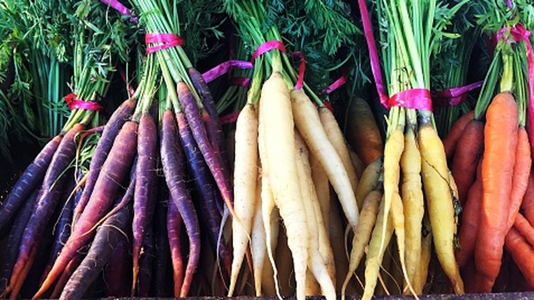 Une variété de carottes colorées du patrimoine sur un étal de marché en plein air
