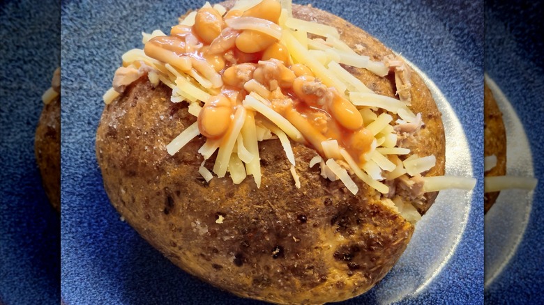 Un plat excellent et copieux, typiquement anglais. Ce sont des pommes de terre en chemise, des pommes de terre entières cuites au four avec la pelure puis farcies. Sur la photo, la pomme de terre est coupée en deux et garnie de thon, de haricots et de fromage cheddar tranché finement.