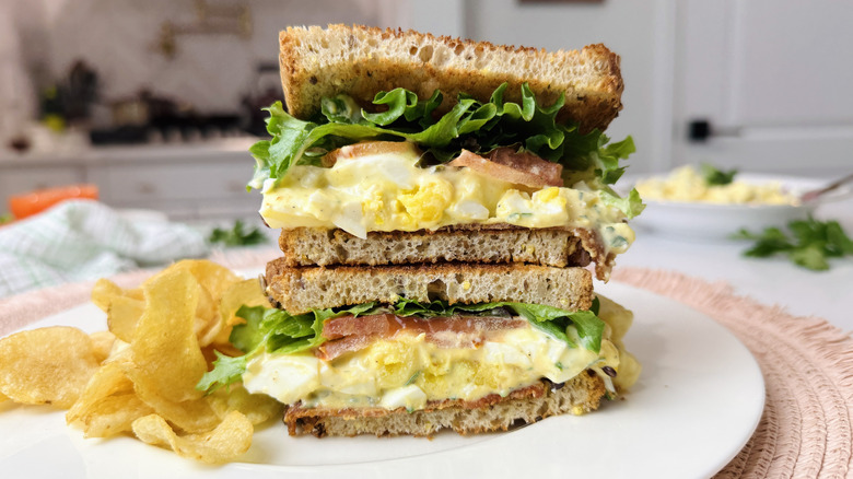Club sandwich à la salade aux œufs sur une assiette avec des frites