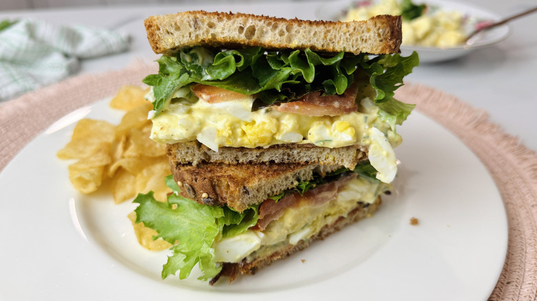 Club sandwich à la salade aux œufs sur une assiette avec des frites