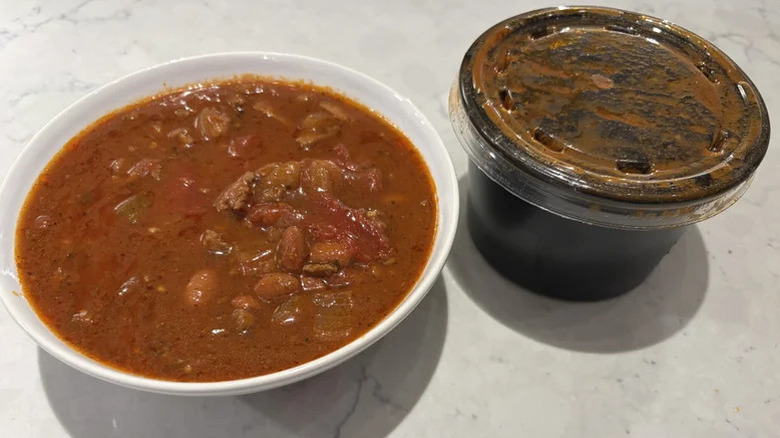 Un bol de chili de la chaîne de sandwichs Quiznos trône sur un comptoir blanc.