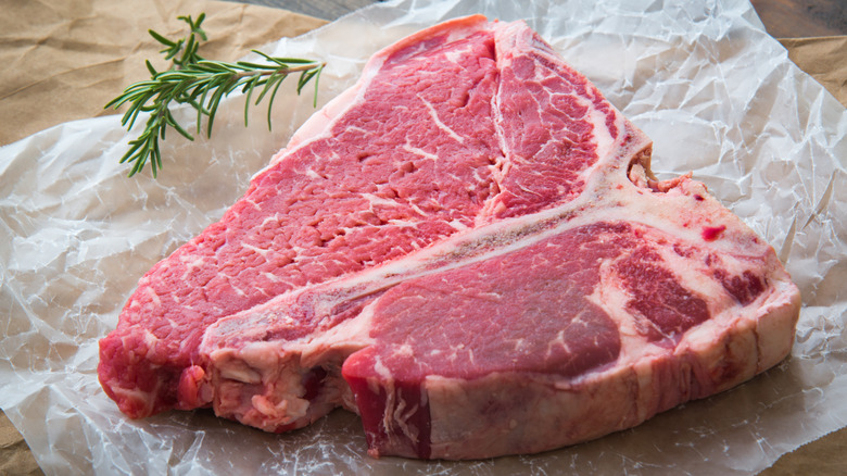Un steak de porterhouse non cuit sur un morceau de papier de boucherie.