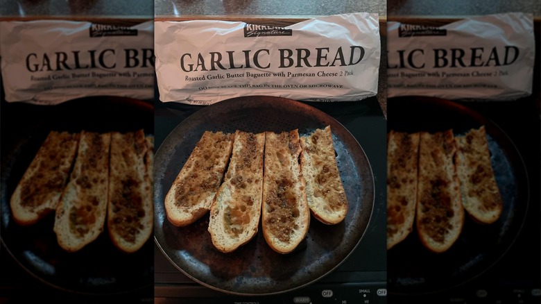 Paquet de baguette au beurre d'ail rôti et au parmesan, avec quelques tranches sur une assiette