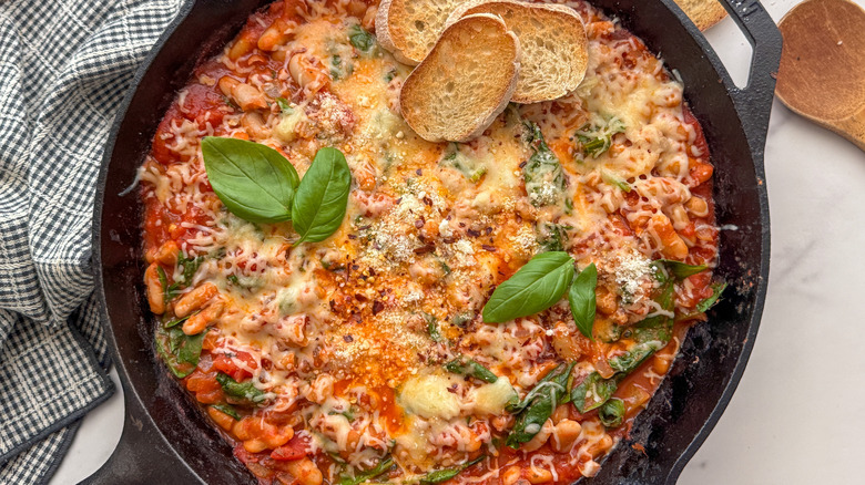Poêle de haricots pizza au fromage avec tranches de basilic et de baguette