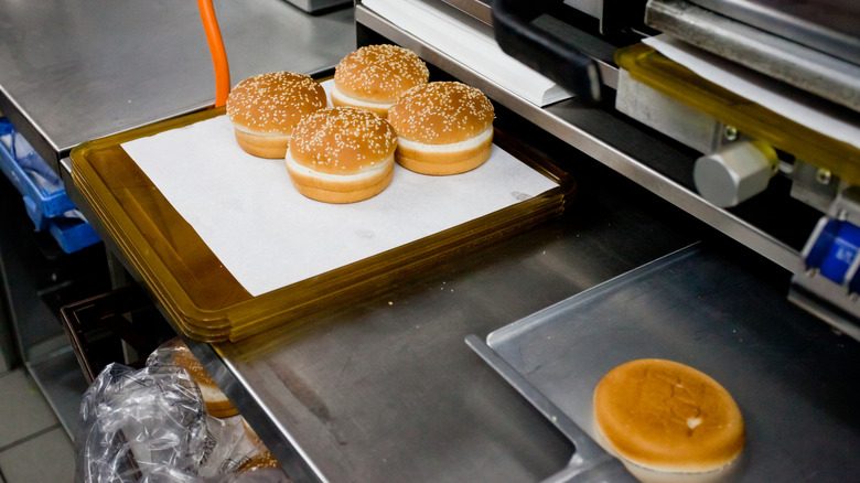 Pains à hamburger garnis de graines de sésame en préparation dans un restaurant McDonald's