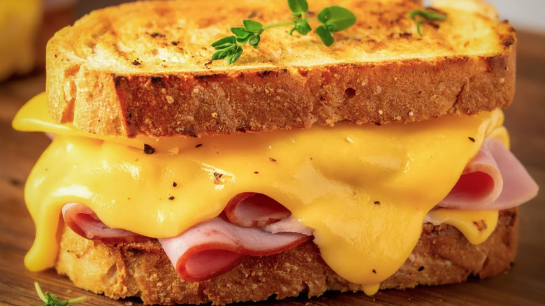Un gros plan d'un sandwich au fromage grillé gluant avec du jambon